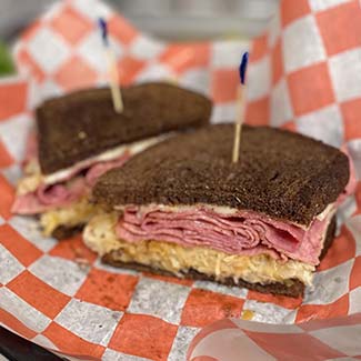 Butch's Pizza Rueben sandwich is rye bread topped with corned beef, sauerkraut and 1000 island dressing